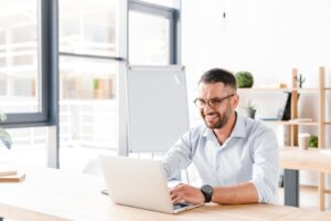 Small business owner working on his laptop reviewing federal contracts.