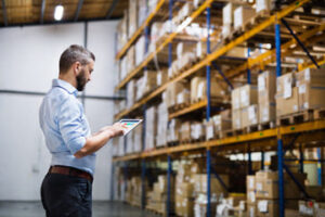 Man reviewing contracts in a warehouse.